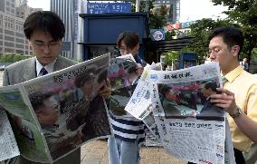 Seoul folk read papers reporting on Korean leaders' meeting